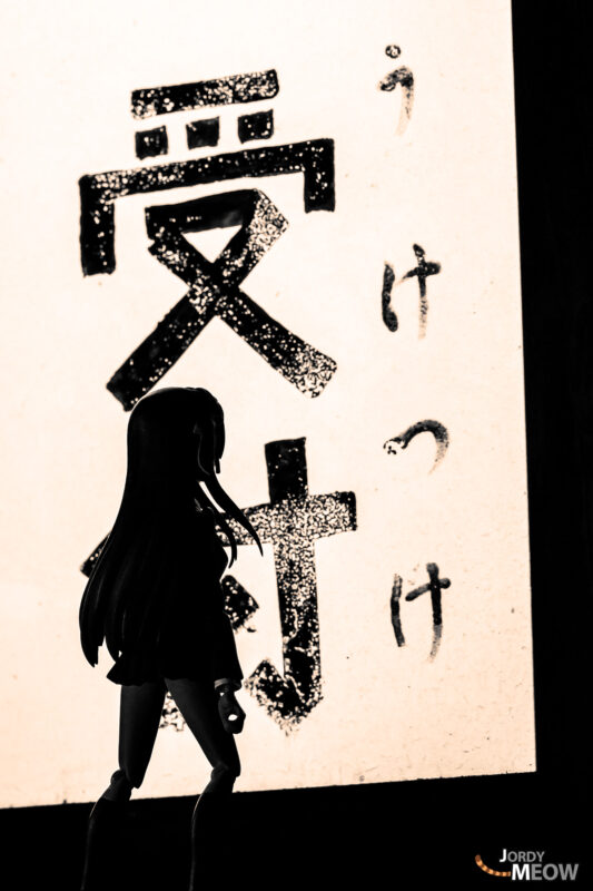 Silhouette facing weathered Japanese clinic sign at abandoned rural doctor’s shack in Japan.