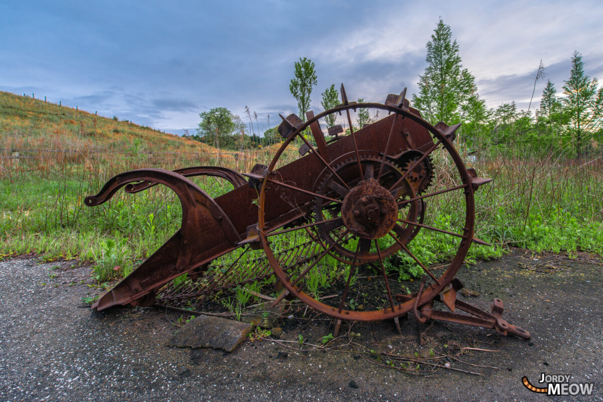 Decaying wheel in abandoned Japanese theme park showcasing natures reclamation of man-made structures.