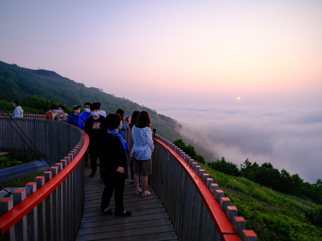 Sunrise over Unkai Terrace walkway above a sea of clouds and mountains