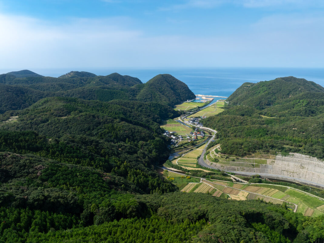 Overlook of Ayumodoshi Natural Park coastal valley, farm fields, river, and ocean horizon