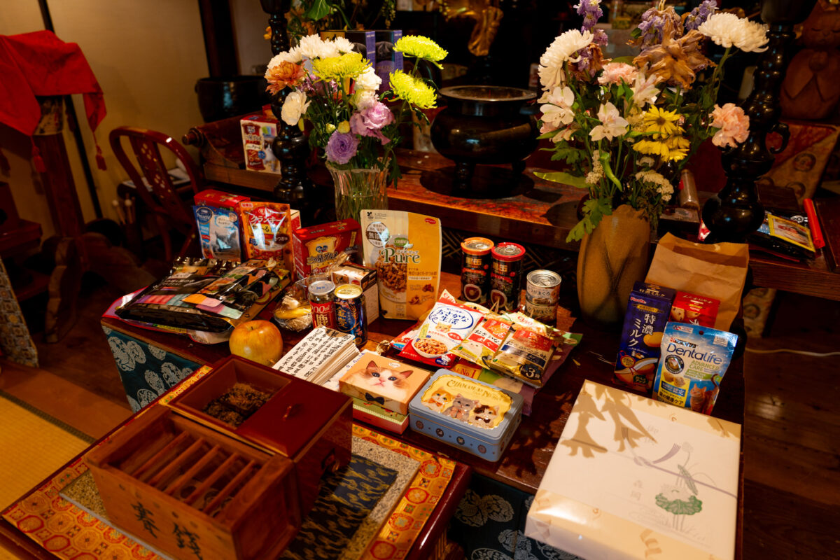 Japanese Buddhist temple altar with food offerings, incense, and fresh flowers at Unrin-ji