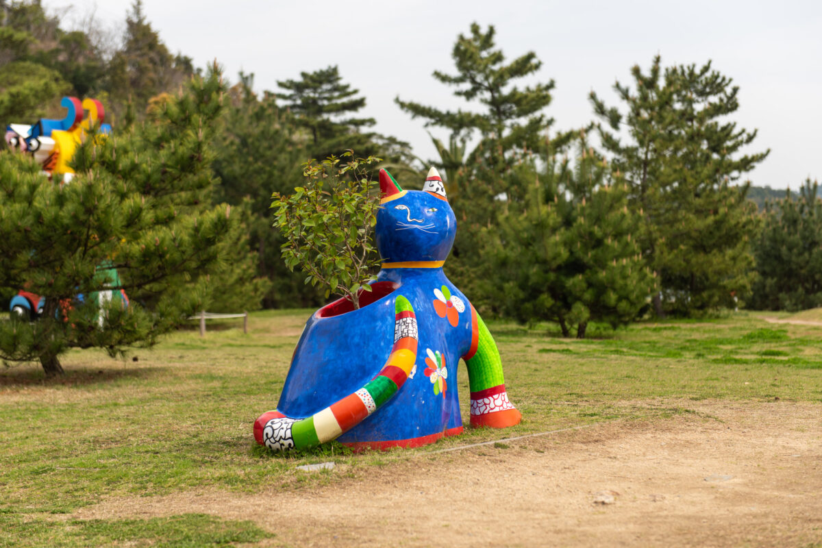 Colorful abstract sculpture on grassy hillside at Naoshima Art Park, Japan