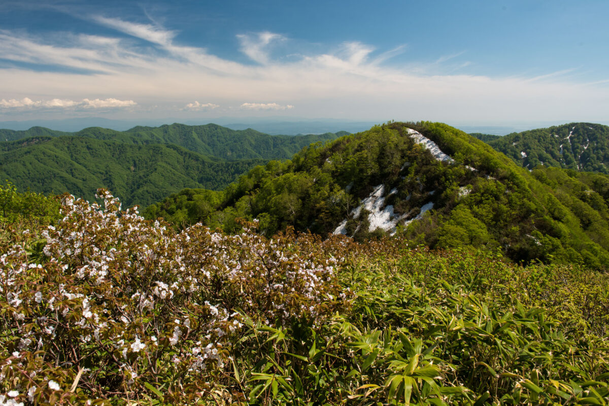 Spring view of Mount Futatsumori ridges with lingering snow patches under blue sky