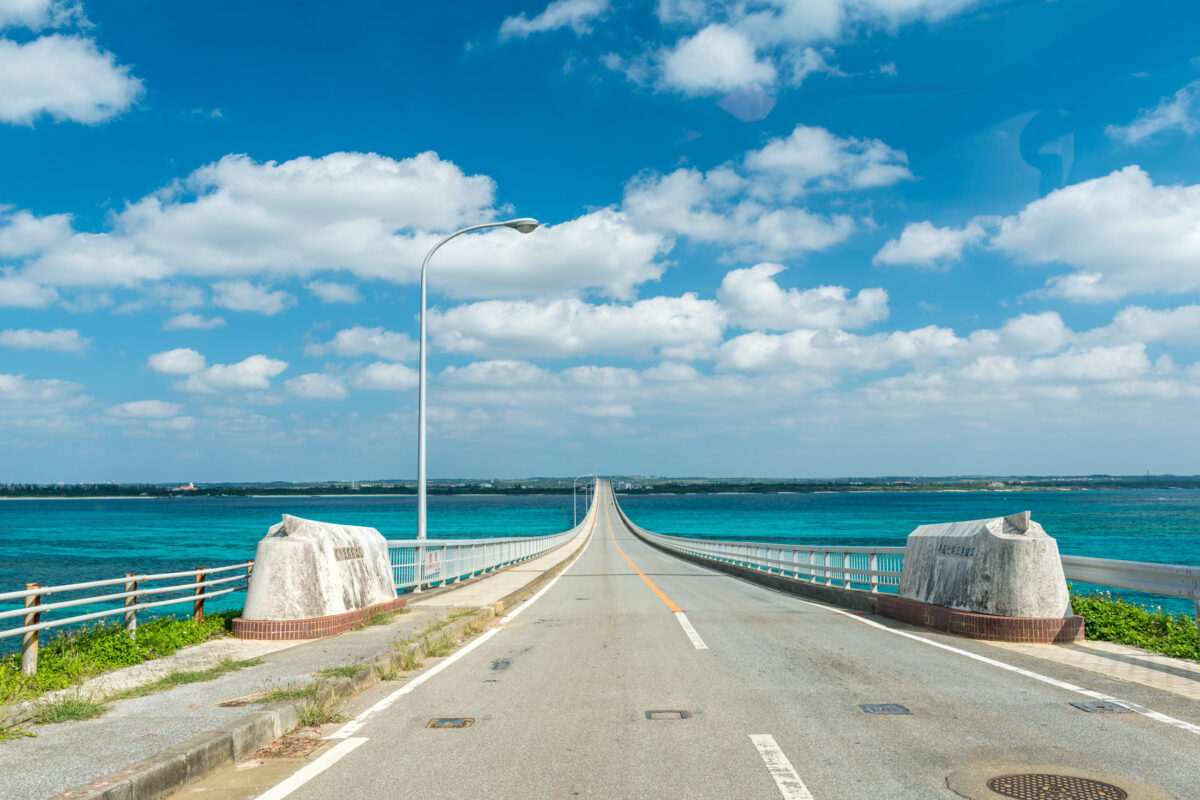 Long bridge over turquoise ocean near Miyako Island, Okinawa, under bright blue sky.