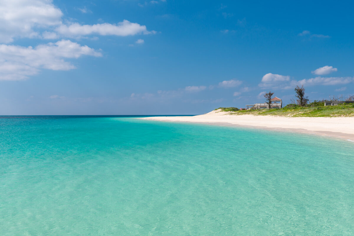 Miyako Island Japan turquoise lagoon beside pristine white sand beach under blue sky