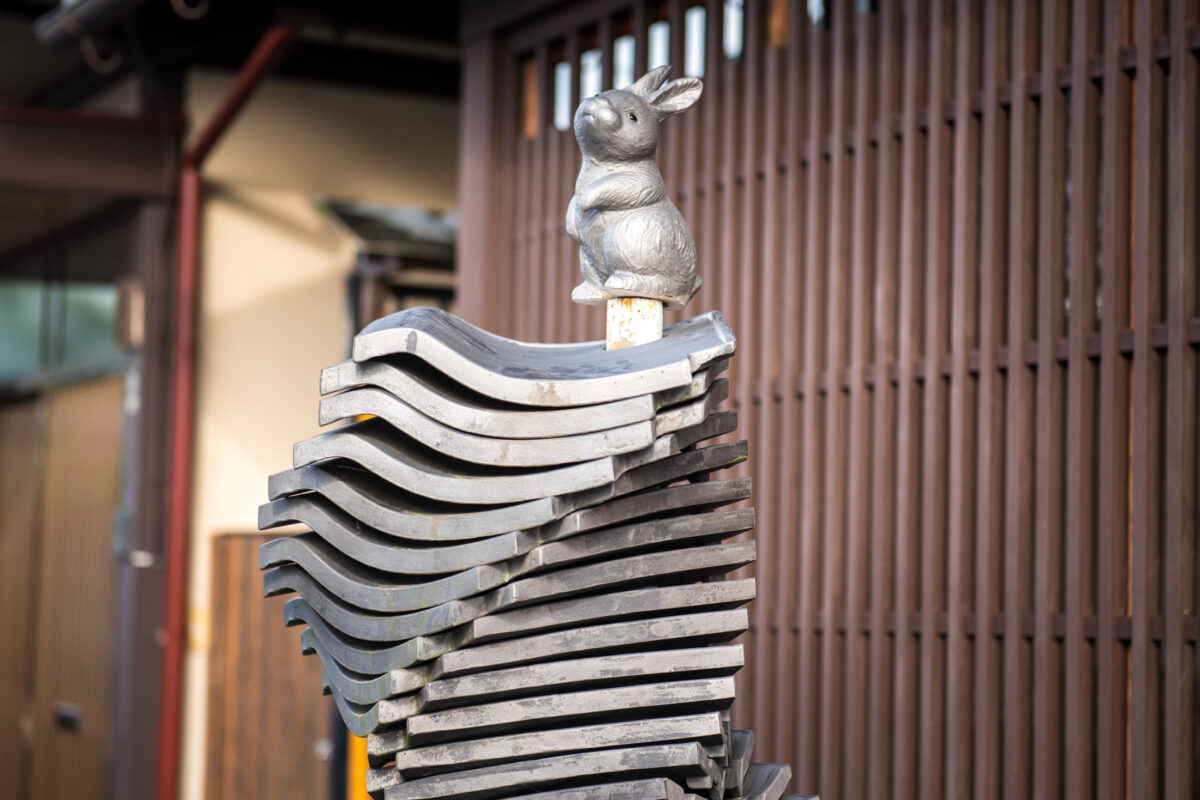 Gray rabbit roof ornament atop traditional Japanese tiles in Omihachiman, Shiga
