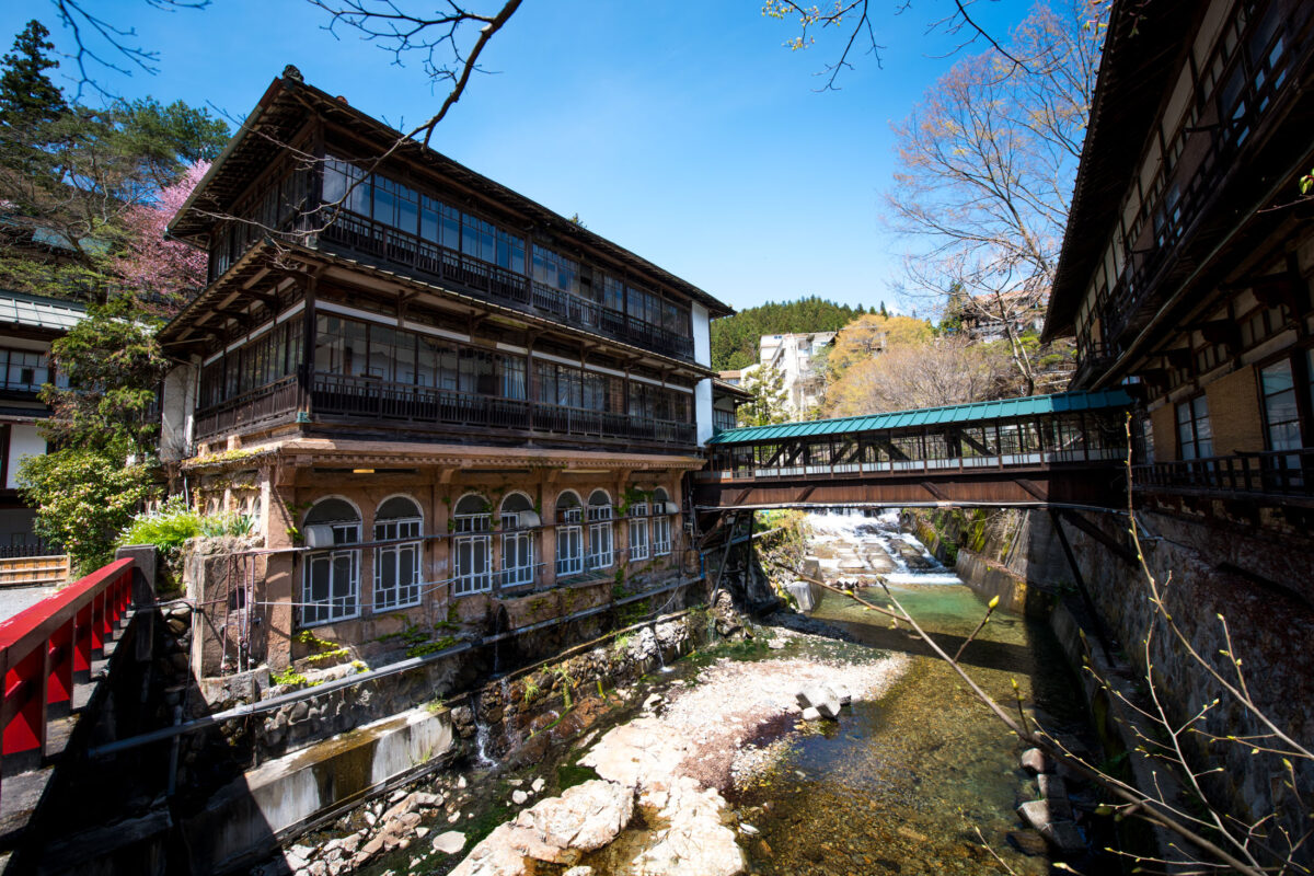 Sekizenkan Ryokan wooden inn beside mountain river with covered bridge in Japan