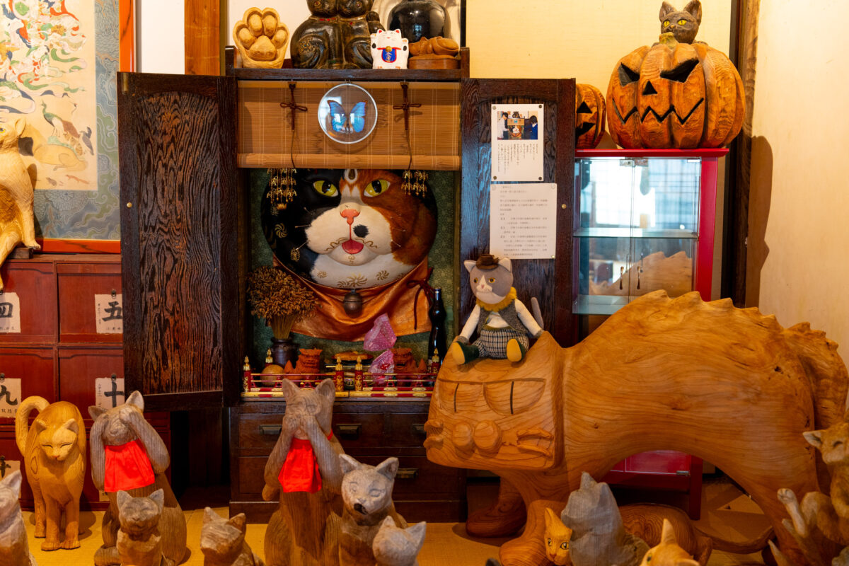 Unrin-ji Temple cat shrine interior with wooden cat figurines and red bibs