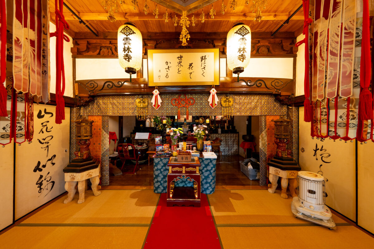 Unrin-ji Buddhist temple altar with red carpet, tatami mats, lanterns, and offerings