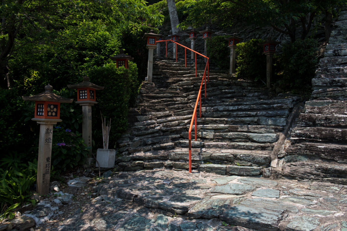 Stone steps with red handrail leading to Wakaura Tenmangu Shrine, Wakayama Japan